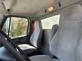 Interior of a 2015 Freightliner M2 106 featuring two gray cloth seats with a steering wheel visible in the foreground
