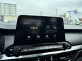 A 2021 Kia Forte dashboard displaying the infotainment screen with radio station 106.5 and options for Android Auto and Apple CarPlay