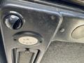 Close-up of a black dashboard panel featuring a circular light and a round air vent on a 2010 Kubota F3990 tractor