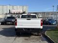 A white 2024 Chevrolet Silverado 1500 seen from the rear with the Chevrolet and Silverado branding prominently displayed on the tailgate