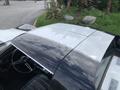 A 1972 Chevrolet Corvette with a two-tone black and silver roof featuring a sleek design and a classic interior visible through the open window
