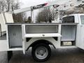 A 2012 Ford F-450 Super Duty truck with an extendable bucket lift and utility compartments on the side