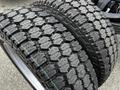 Close-up of two new tires with a heavily treaded design suitable for the 2024 Ford F-550 showcasing their durable rubber composition and deep grooves