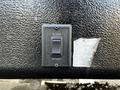 A black control switch labeled EXTEND and RETRACT mounted on a textured surface with a faded instruction sticker adjacent to it