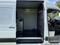 A 2017 Mercedes-Benz Sprinter van with an open rear door revealing a spacious cargo area featuring grey walls and a black floor