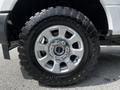 Close-up of a 2017 Ford F-250 SD wheel featuring an intricate silver rim and an all-terrain tire with deep treads