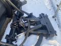 A 2000 plow with a 12-foot attachment featuring hydraulic components and chain links visible on a snowy surface