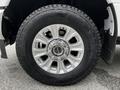 Close-up of a silver alloy wheel with a black tire from a 2020 Ford F-350 SD showcasing a rugged tread pattern and a shiny hubcap