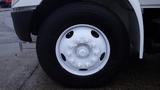 Close-up of a white wheel rim with bolts on a black tire belonging to a 2005 International 4300 vehicle