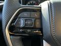 Close-up of the steering wheel controls in a 2023 Toyota Tundra featuring buttons for navigation phone and audio functions