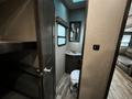 Interior view of a 2021 Grand Design Recreational 311BHS showing a bathroom area with a sink and toilet adjacent to a bunk bed space