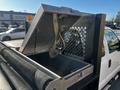 The image shows a 2011 Ford F-350 SD with an open metal storage compartment featuring a hinged lid and securing strap