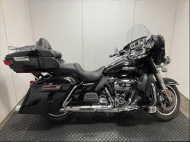 A 2017 Harley-Davidson Flhtcu motorcycle featuring a black finish a touring seat saddlebags and a large front fairing with a windshield