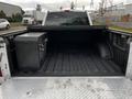A 2016 Ford F-150 with an open truck bed featuring a diamond plate toolbox on the left side