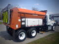 A 2016 International WorkStar 7500 dump truck with a bright orange and black rear dump body and large tires