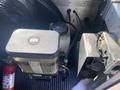 A close-up view of the engine compartment of a 2012 Ford Econoline showing the coolant reservoir and accompanying hoses
