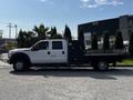 A 2016 Ford F-550 with a flatbed and toolboxes on the sides parked on a gravel surface