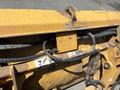 Close-up of the hydraulic components and controls of a 2011 Case 570 MXT construction loader featuring yellow metal and visible hoses and labels