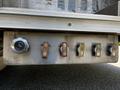 A metal control panel on a 2006 Emergency One Fire Truck featuring several labeled valves for different functions