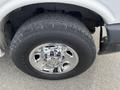 A shiny chrome wheel with a large tire from a 2013 Chevrolet Express featuring a Chevrolet logo in the center