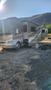 A 2007 Winnebago Adventure RV with a slide-out section parked on dry grass