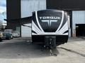 A 2022 Heartland Torque travel trailer featuring a sleek black and white exterior with the brand name Torque prominently displayed on the front