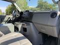 Interior view of a 2011 Ford Econoline showing the dashboard seats and center console with storage compartments