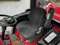 A black fabric seat inside a red Toro Groundsmaster with controls and a steering wheel visible in the foreground