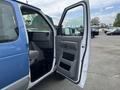 A blue 2009 Ford Econoline van with the driver's side door open showing the interior and dashboard