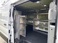 A 2023 Ford Transit with the rear doors open revealing a spacious interior fitted with metal shelving for storage