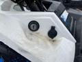 Close-up of the ignition key slot and a small cover on a 2017 Polaris Scrambler with water droplets on the surface