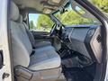 Interior view of a 2016 Ford F-550 showing the driver and passenger seats with gray upholstery and a dashboard featuring controls and storage compartments