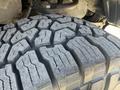 Close-up of a rugged tire with deep treads from a 2010 Toyota Tacoma showing wear and pattern designed for off-road traction