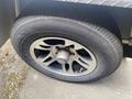 A close-up of a flat tire on a 2020 Stealth Enterprises Trailer featuring a five-spoke alloy wheel and a black tire with tread patterns visible