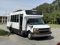 A white 2020 Chevrolet Express bus with black accents and a sign displaying the word SORRY on the front