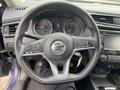 Steering wheel of a 2019 Nissan Rogue featuring controls for audio and cruise settings along with a visible instrument cluster and dashboard displays