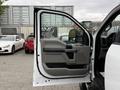 A 2020 Ford F-550 truck with the driver's side door open revealing the interior door panel and controls