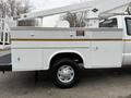 A white 2001 Ford F-350 utility truck featuring a service body with a mounted bucket lift and a single rear wheel