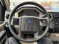 A 2008 Ford F-350 steering wheel with the Ford logo at the center and various controls on the spokes