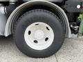 Close-up of a black tire with the brand name Arisun and the model number A718 on a white steel wheel mounted on a 2006 Sterling L7500 truck