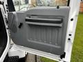 The interior door panel of a 2013 Ford F-650 featuring a textured gray surface and a black door handle