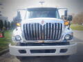 A 2016 International WorkStar 7500 truck with a shiny chrome grille large headlights and side mirrors visible in the foreground