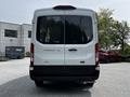 White 2022 Ford Transit van viewed from the rear with the word "TRANSIT" displayed prominently on the back near the center and "AWD" at the bottom left