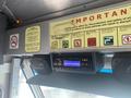 A 2012 Ford Econoline van interior featuring a digital radio display and a series of informational signs related to safety and regulations