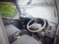 Interior view of a 2003 Toyota Toyoace showing the steering wheel dashboard and gear shifter with fabric-covered seats