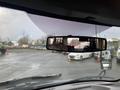 A 2018 Chevrolet Express viewed from the driver's seat with a focus on the rearview mirror reflecting the interior and exterior vehicles