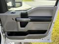 A 2018 Ford F-550 door panel featuring a power window control a grab handle and a textured armrest in a two-tone gray and black color scheme