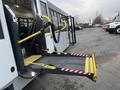 A 2017 Chevrolet Express with a wheelchair ramp extended at the rear entrance designed for accessibility