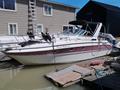 A 1991 Larson Mirado motorboat docked with a white hull and a pink stripe named Slow Motion on the side