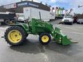 A 2003 John Deere 790 tractor with a green and yellow color scheme features large rear wheels and a front loader attachment